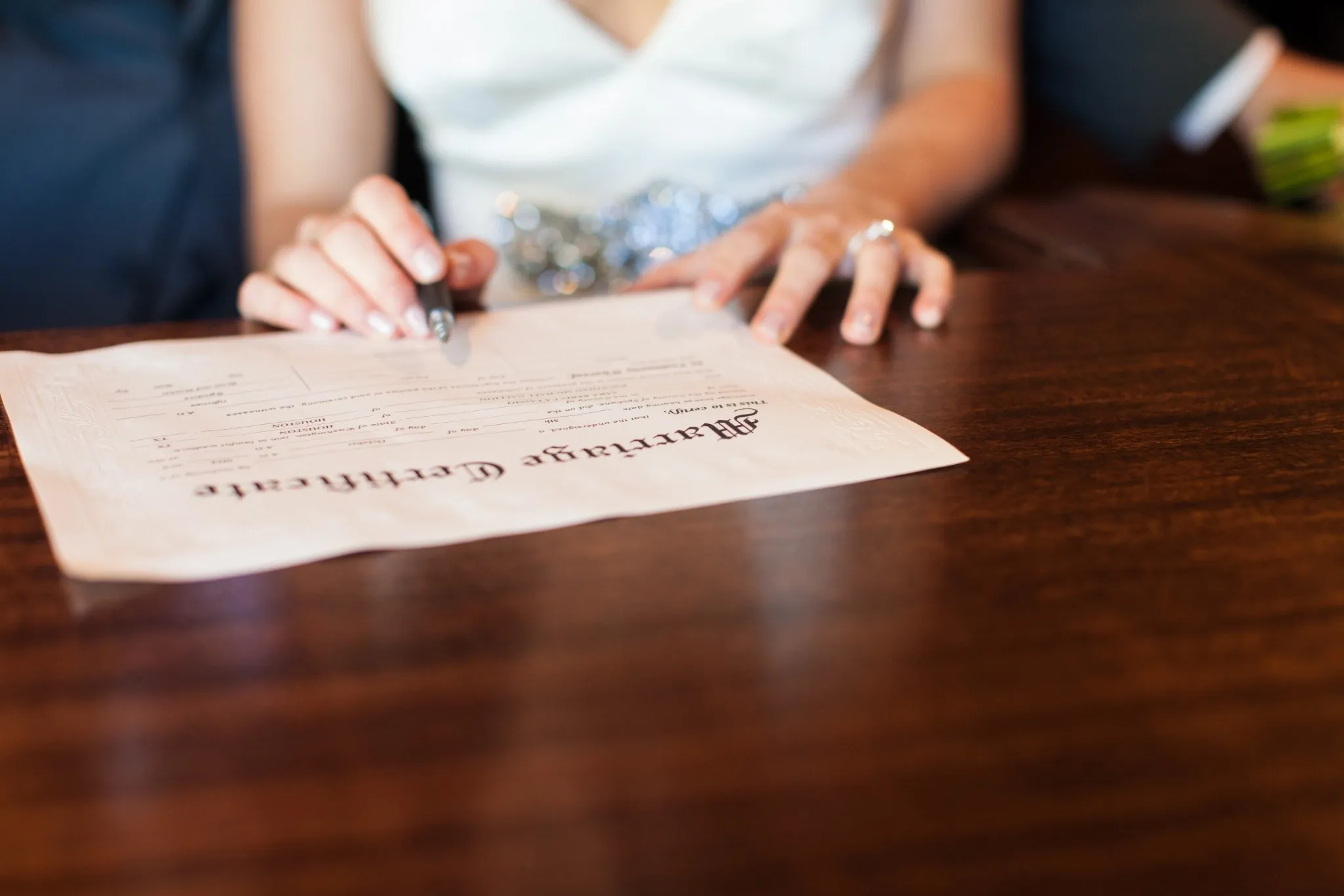 : Bride signing marriage certificate at wedding ceremony, illustrating how to correct marriage certificate errors