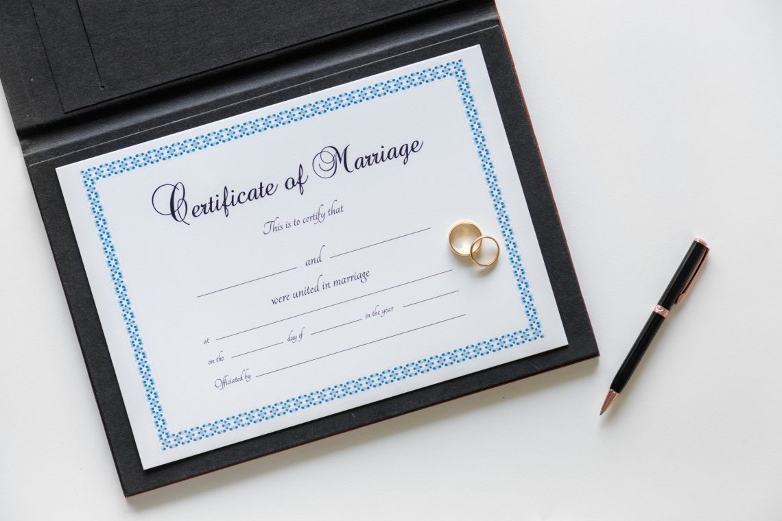 : Bride signing marriage certificate at wedding ceremony, illustrating how to correct marriage certificate errors