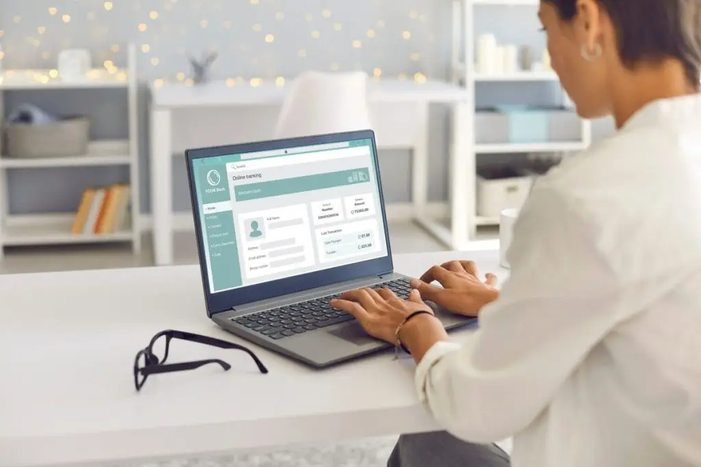 Woman updating bank account and credit card name after marriage on a laptop