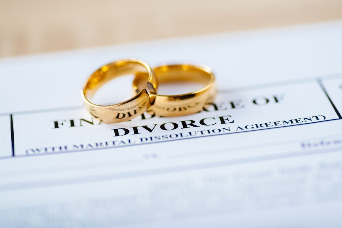 Wedding rings on divorce paperwork illustrating name change after divorce in New Jersey