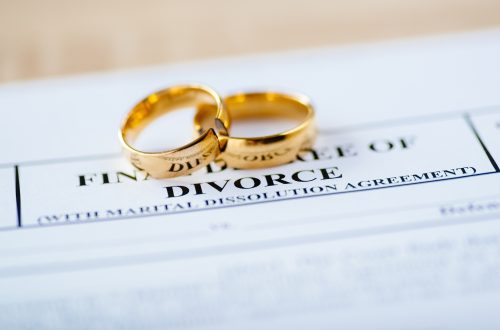 Wedding rings on divorce paperwork illustrating name change after divorce in New Jersey